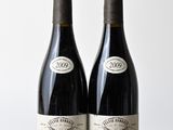 deux bouteilles de vin posées l'une à côté de l'autre sur une table en bois