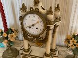 a clock that is sitting on a table next to some candles