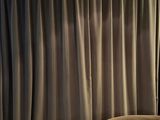 des rideaux dans un salon avec un fauteuil et une lampe