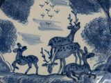 a blue and white plate with a picture of a deer and two deers on it