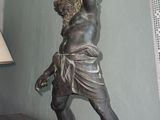 a statue of a man holding a tray on a table