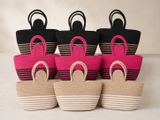 quatre paniers de couleurs différentes, munis d'anses, posés sur un fond blanc