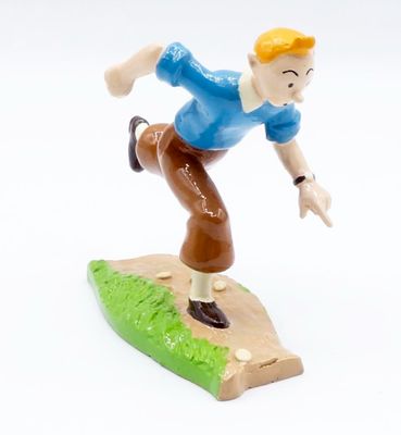 a toy figurine of a boy on a surfboard