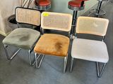 several chairs and stools in a room with a bar in the background
