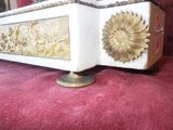 a white and gold box with a sunflower design on it