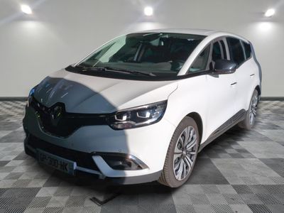 la voiture blanche est garée sur un sol en damier dans le garage