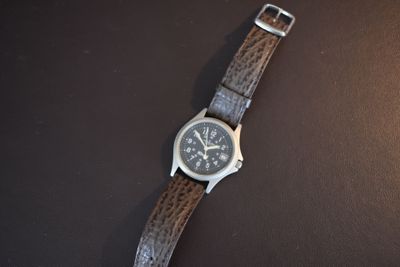 a watch that is sitting on a black surface