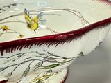 a white bowl with a red rim and a flower design on it