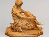 statue représentant une femme assise sur un tabouret, un livre à la main