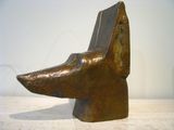 sculpture of a dog ' s head on a table with a white wall in the background
