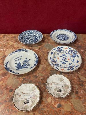 plusieurs assiettes bleues et blanches posées sur une table, avec un mur rouge en arrière-plan