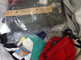 a bag full of clothes sitting on top of a bed