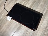 a black stove top with two burners on it on a wooden floor