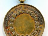 un gros plan d'une médaille posée sur une surface blanche, sur fond blanc