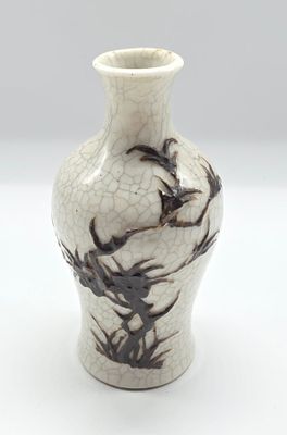 un vase blanc orné d'un motif noir