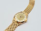 an image of a close up of a gold watch on a white surface