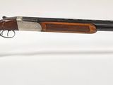 le fusil est exposé sur un socle en acrylique transparent