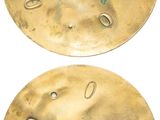 two brass discs with holes and holes in them on a white background