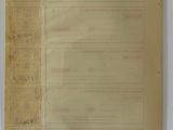 an old document is sitting on a table next to a wall