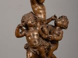an antique bronze statue of a boy and two cherenshes on a table