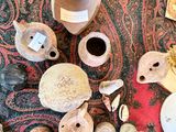many different types of pottery sitting on a rug