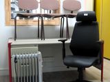 une chaise de bureau noire posée devant un radiateur