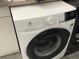 a stack of clothes on top of a washer in a kitchen
