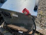 a metal box with a cord attached to it on the ground