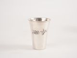 un verre à shot argenté portant une inscription sur un fond blanc
