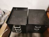 two black filing cabinets sitting next to each other in a room