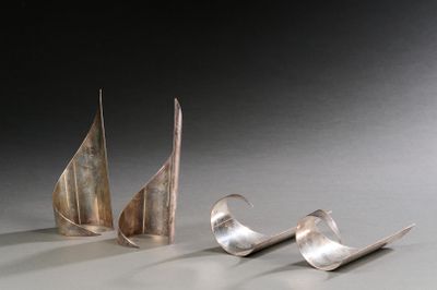 trois objets métalliques argentés posés sur une table