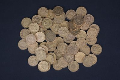 a pile of old coins on a blue surface