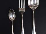 three silver spoons and two silver spoons on a black table