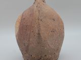 a small brown vase sitting on a white surface