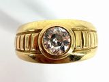 a close up of a gold ring with a diamond on it