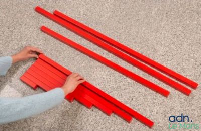 someone is cutting red strips on the floor with a pair of scissors