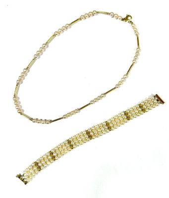 a close up of a bracelet and a necklace on a white surface
