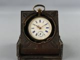 une petite horloge posée sur une table