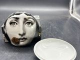 une petite assiette blanche sur laquelle est représentée une femme, à côté d'une autre petite assiette blanche