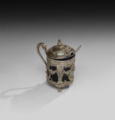 une théière ancienne en argent avec son couvercle, posée sur une surface blanche