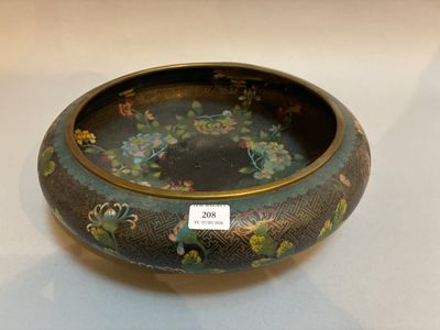 un bol noir orné de fleurs, posé sur une table