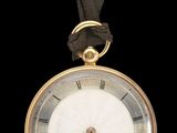 une image représentant une montre de poche plaquée or, entourée d'un ruban noir