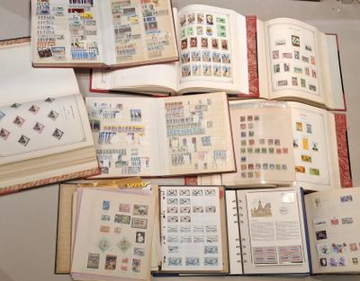 plusieurs livres ouverts, sur lesquels sont apposés des timbres, posés sur une table