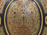 an ornate black and gold painted cabinet with a red and gold design