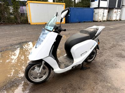 a scooter that is parked on the side of the road