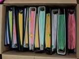 une boîte remplie de nombreux dossiers en papier de différentes couleurs