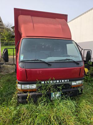 un camion rouge garé dans l'herbe