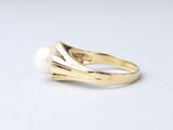 an image of a gold ring with a pearl in the middle