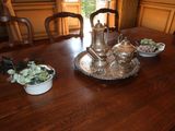 a table with a silver tea pot and bowls of food on it