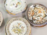 several plates with different designs are arranged on a white surface